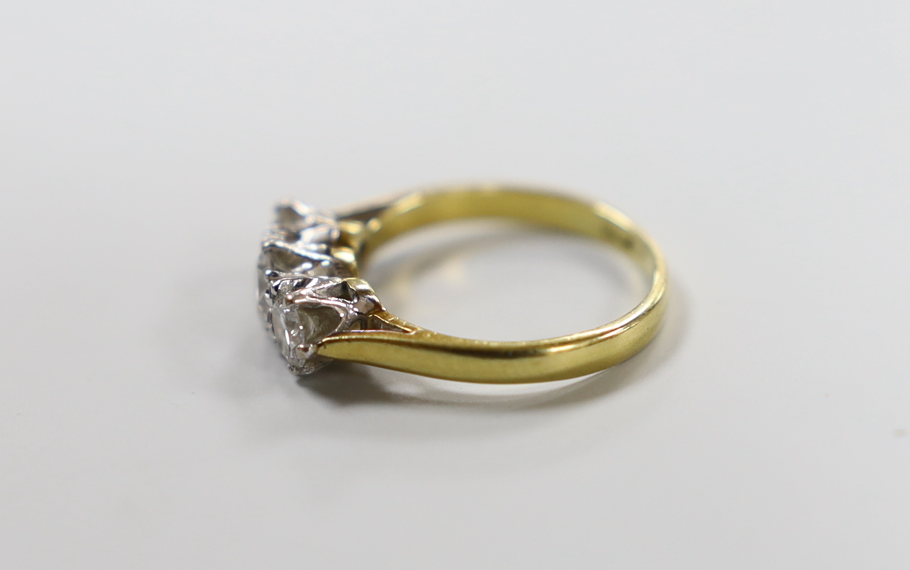 A modern 18ct gold and three stone diamond set ring, size I, gross weight 2.9 grams.